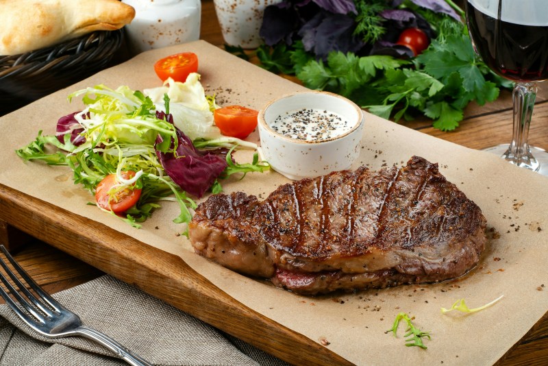 Steak and salad on cutting board