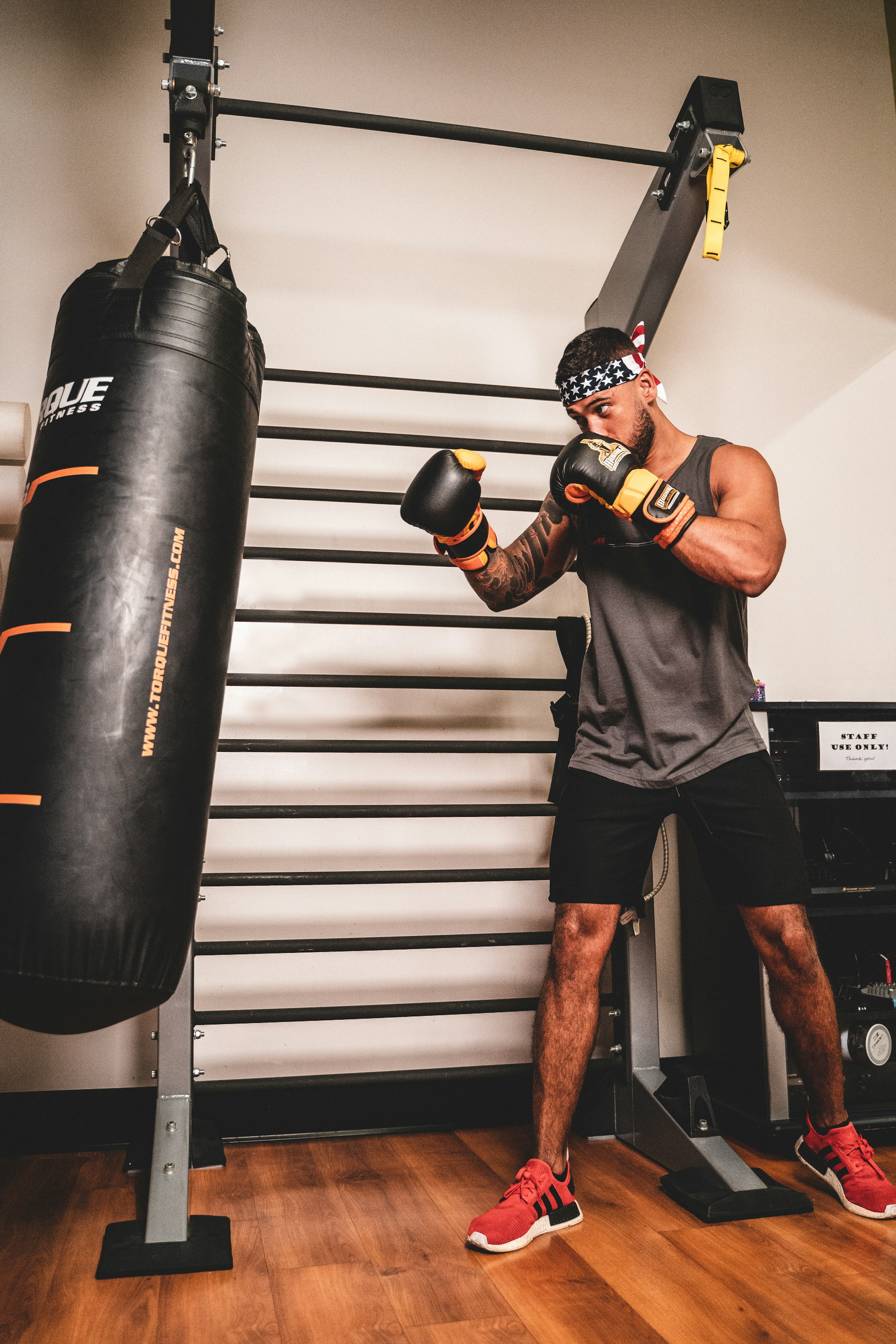 man boxing with punching bag headband wooden floor