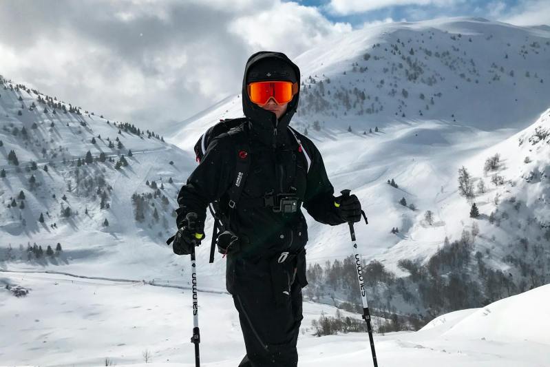 man holding ski poles skiing standing by snowy mountain